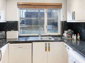 Eine Küche mit Fenster, Spüle, Toaster und Brokasten.