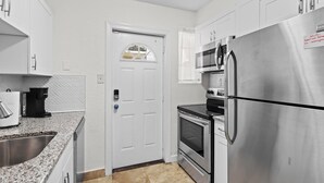 A modern kitchen with white cabinets, stainless steel appliances, a built-in oven, and a microwave. - "Davis Islands Charm! Euro Oasis Walkable to Events, Eats & Care!" (Tampa)