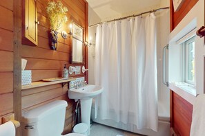 Bathroom features a toilet, pedestal sink, shower, and mirror.