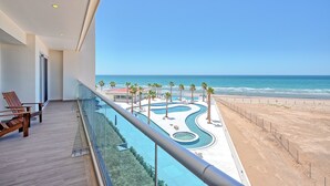Un balcon avec vue sur une piscine et une plage.
