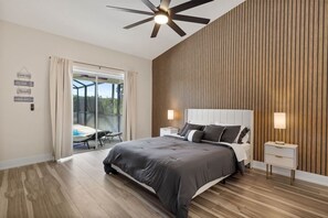 Relax in this serene bedroom with a large bed, bedside tables, and a ceiling fan.