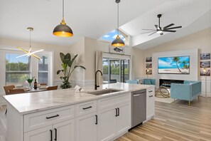 Enjoy cooking in the spacious kitchen with a central island, sink, and ample storage, complemented by a dining area with a large window.