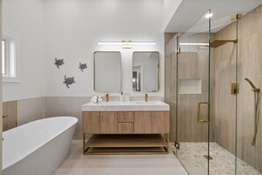 Enjoy a relaxing soak in the bathtub or refresh in the glass-enclosed shower area.