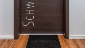 A dark wooden door with the name "SCHWABACHAUEN" and the number "7" on it.