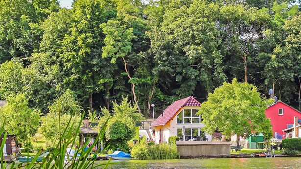 Une propriété au bord du lac comprenant une maison, un quai et des bateaux.