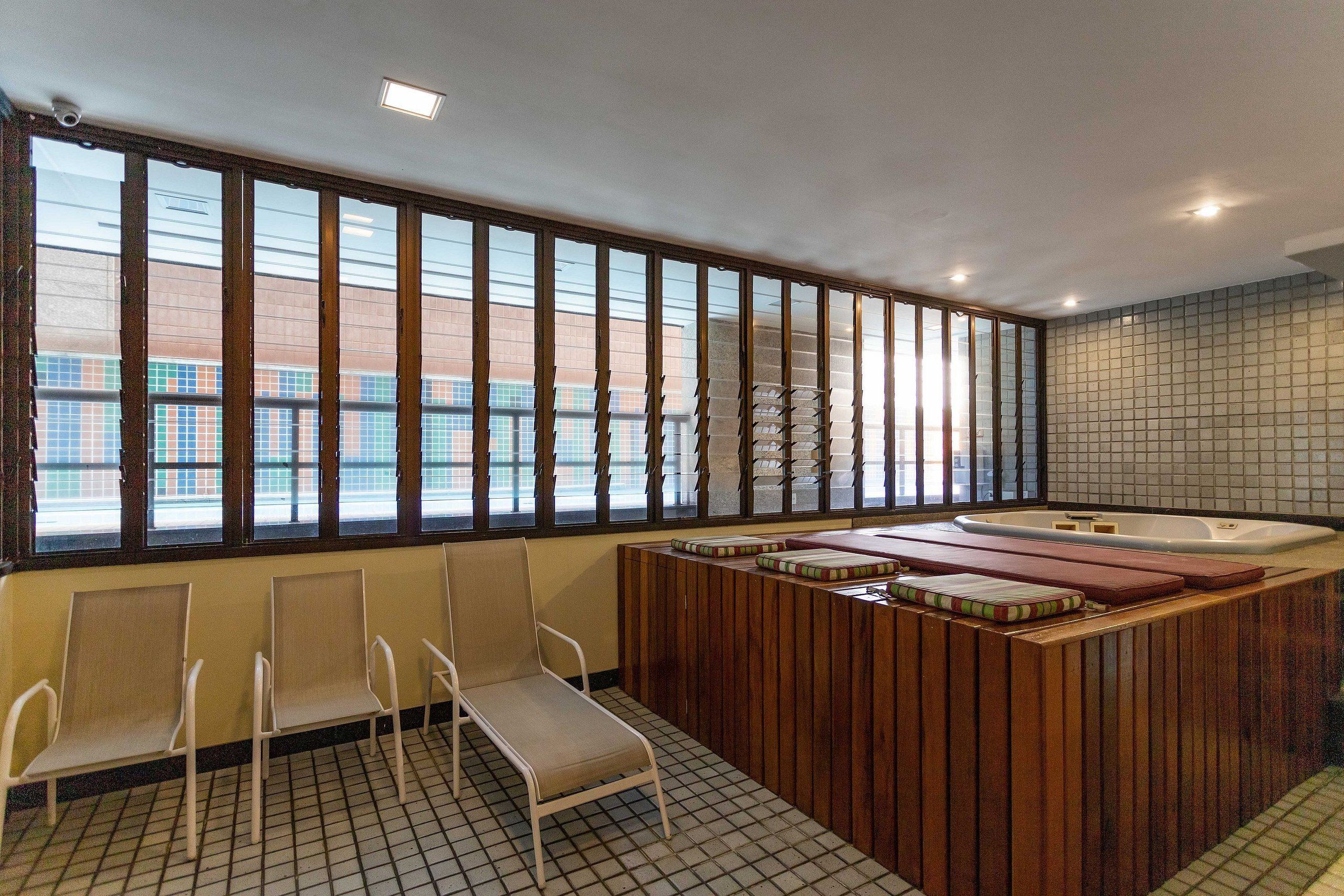 A spa area with a hot tub, seating, and large windows.