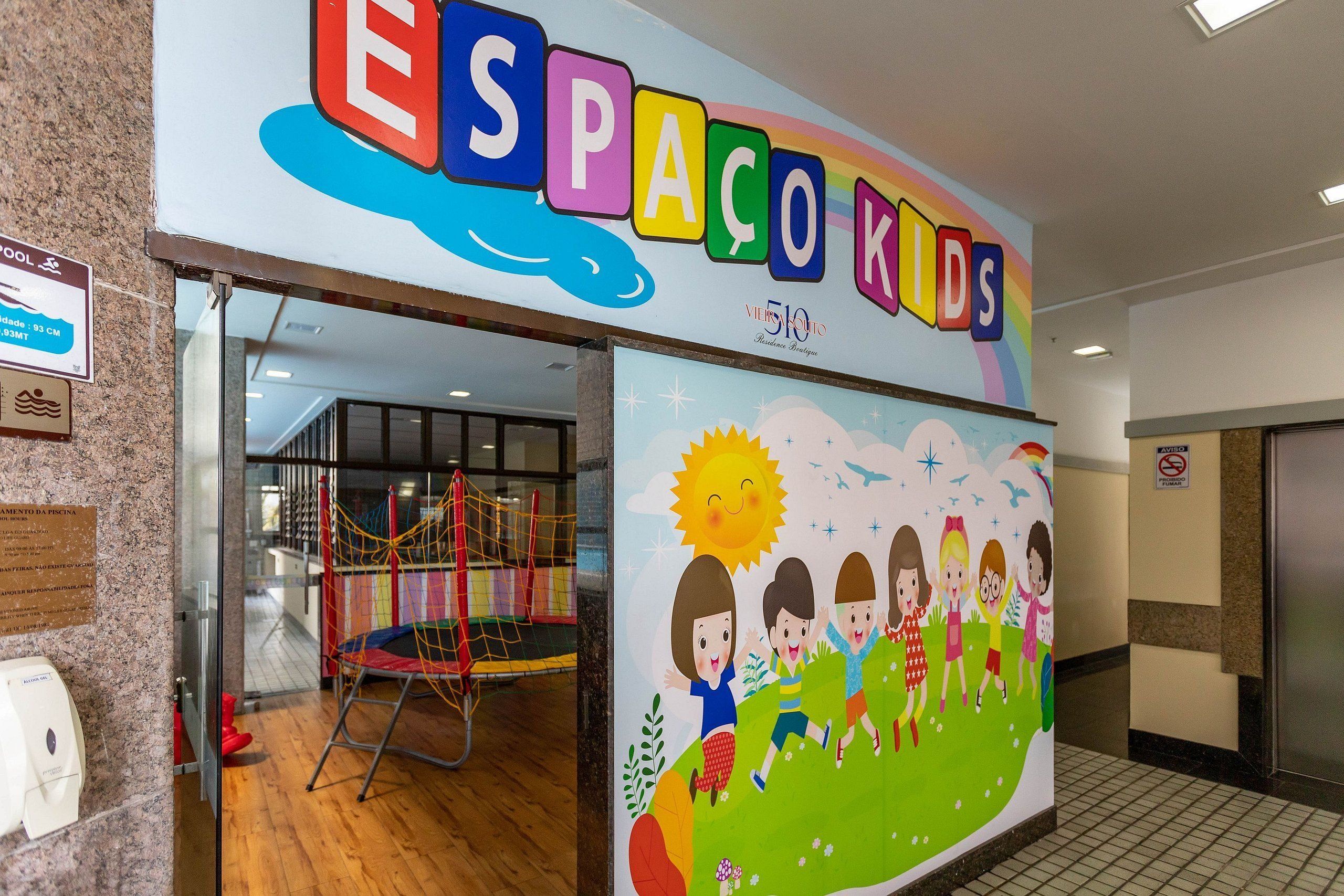A children's play area with colorful signage and a mural of children playing outdoors.