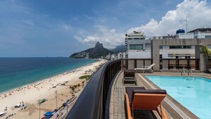 Une piscine sur le toit offrant une vue sur une plage et une montagne.