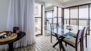 A modern dining area with a glass table and chairs, a buffet tray, and a view of the outdoors. - 802 (Rio de Janeiro)