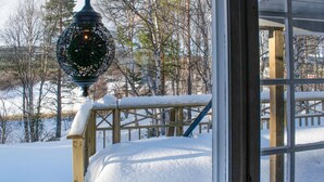 A wooden deck with snow accumulation, a metal railing, and a decorative lamp post. - Gorgeous home in os i østerdalen (Os i Østerdalen)