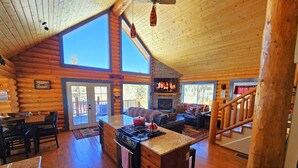Ein Blockhaus-Interieur mit Küche, Essbereich und Wohnzimmer.