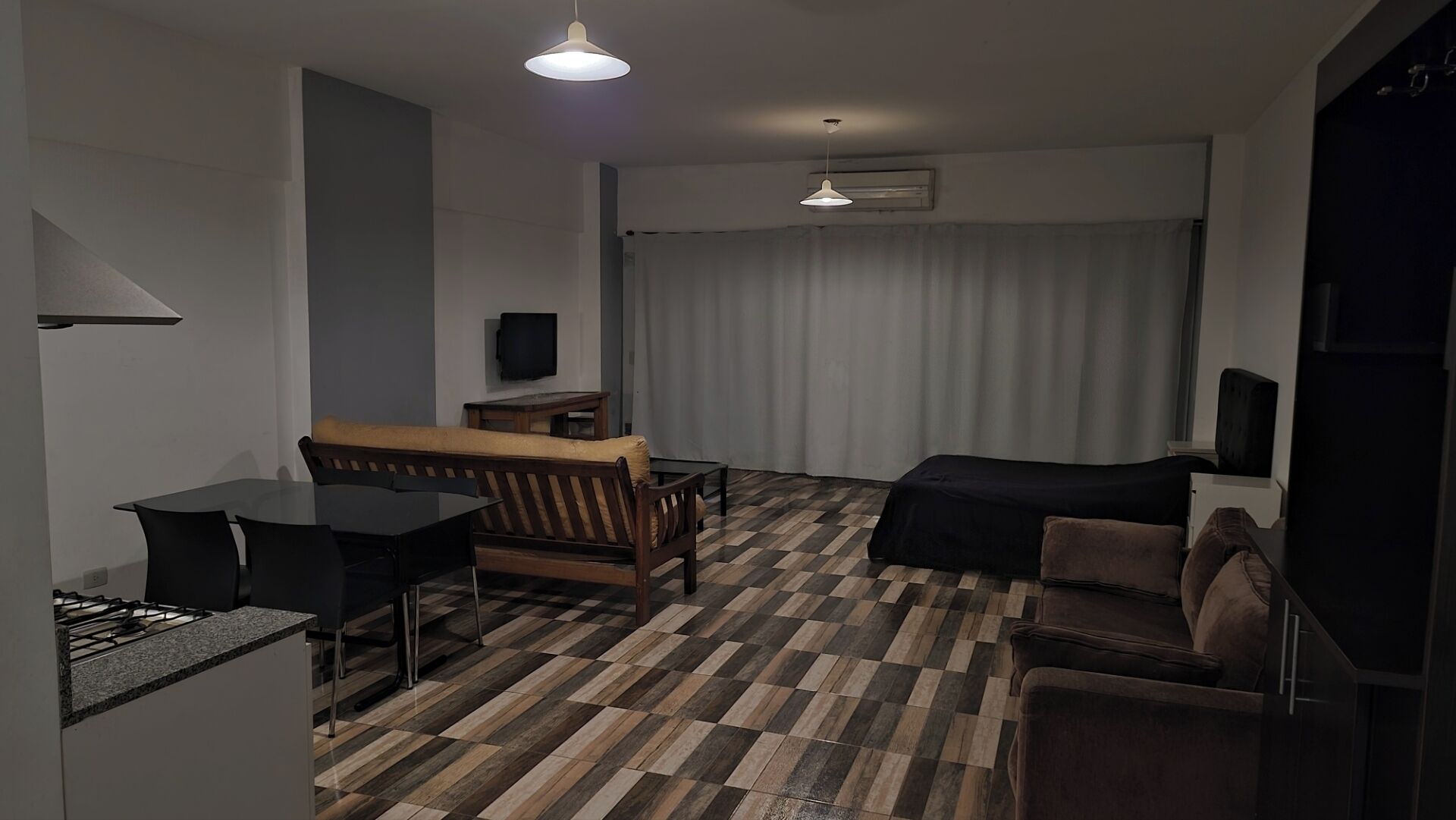 Una habitación de hotel moderna con una mesa de comedor, sofá y cama.