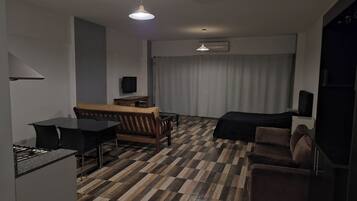 Una habitación de hotel moderna con una mesa de comedor, sofá y cama.