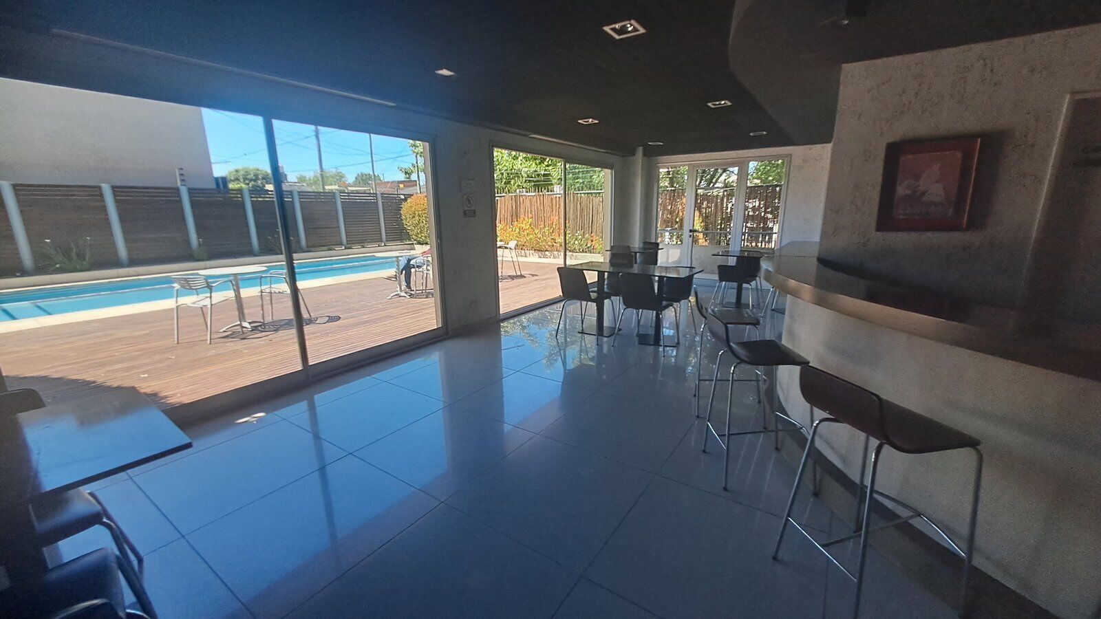 Amplio espacio interior con vista a la piscina, muebles modernos y zona de bar.