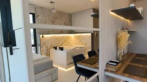 A modern interior with a dining area, a sofa, and a kitchen. - Republica del Salvador Coliving Ecuador (Quito)