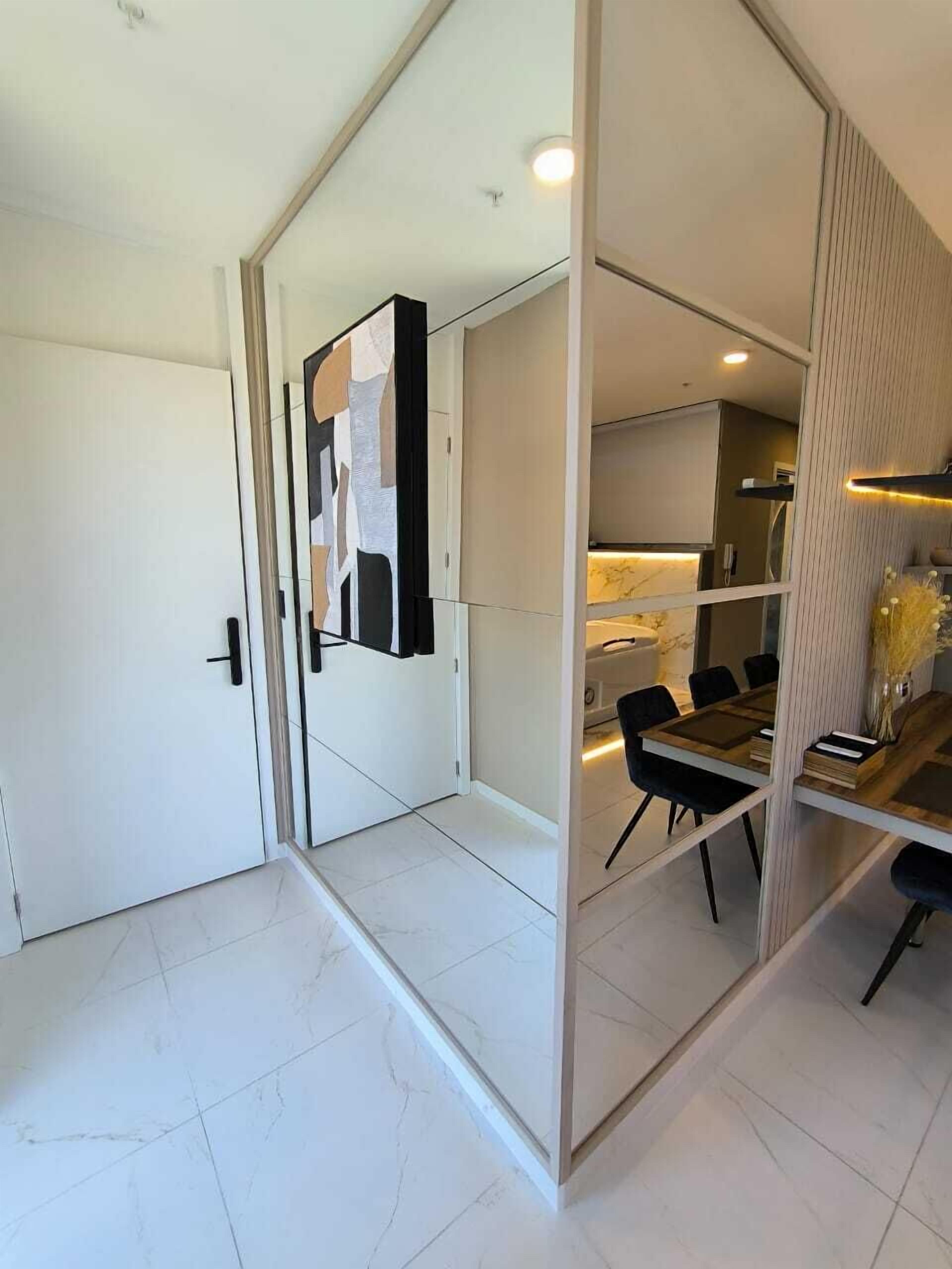 A modern interior with a dining area, a kitchen, and a white door.