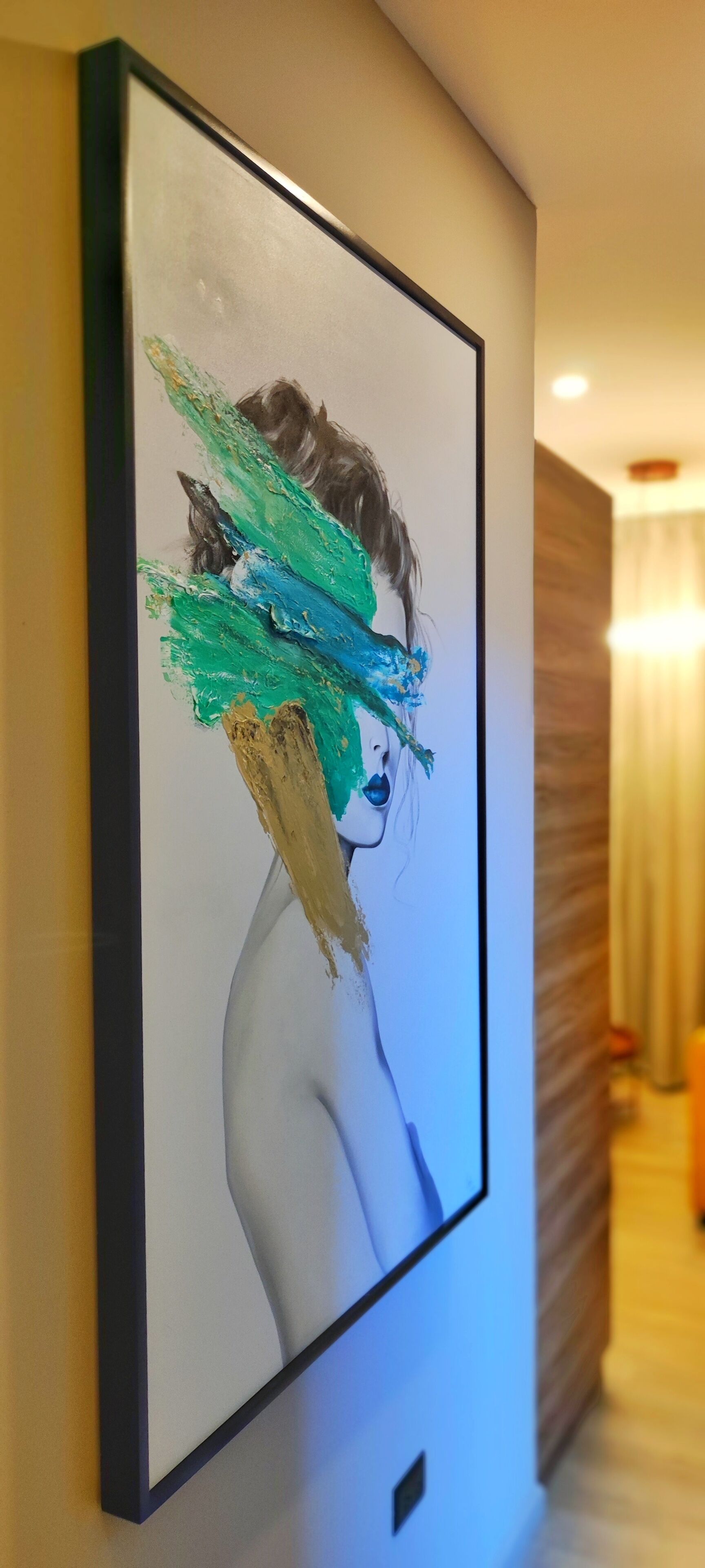 A framed artwork on a wall in a hotel corridor.
