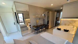 A modern living room with a sofa, a dining area, and a bathroom with a bathtub. - Republica del Salvador Coliving Ecuador (Quito)