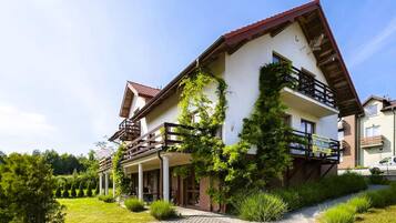 Une maison à deux étages avec un balcon et un jardin.
