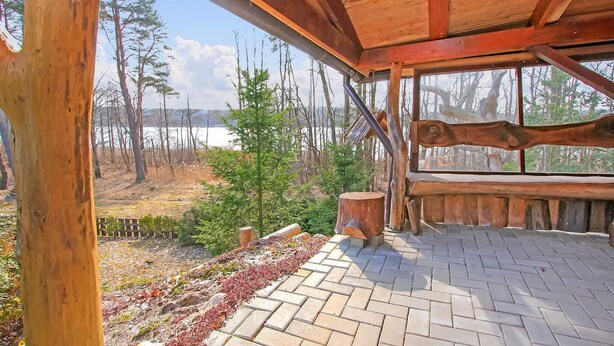 Una terraza de madera con vistas a un bosque y un lago.