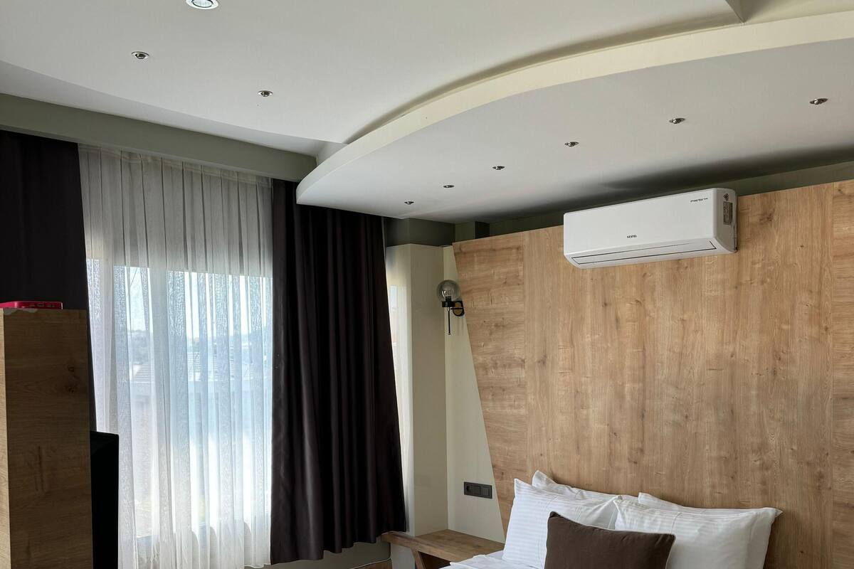 Un dormitorio moderno con una cama grande, cabecera de madera y armario empotrado.