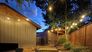 An outdoor patio area with wooden chairs and a stone pathway.