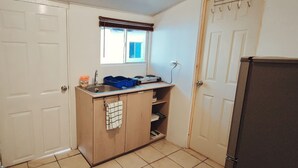Una cocina compacta con ventana, un lavamanos, una estufa y un refrigerador.