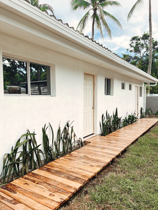 Un edificio blanco con una terraza de madera que conduce a la entrada.