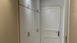 A hallway with white walls, a white door, and a white wardrobe with handles. - Apparemment Haut Standing 170m (Tunis)