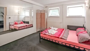 A bedroom with two beds, a large mirror, and a window with blinds. - Ferienwohnung Bansin (Seebad) (Bansin (Seebad))