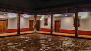 A spacious indoor area with tiled flooring, multiple doors, and a high ceiling. - Hotel Hacienda Maravillas (Nopala)