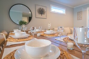 Enjoy a formal dining experience in this elegantly set room with a table for meals, comfortable seating, and a beautiful view.