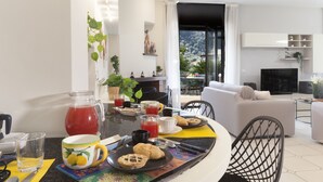 A modern living room with a dining area, featuring a sofa, a coffee table, and a TV. - Maison Wally (Sorrento)