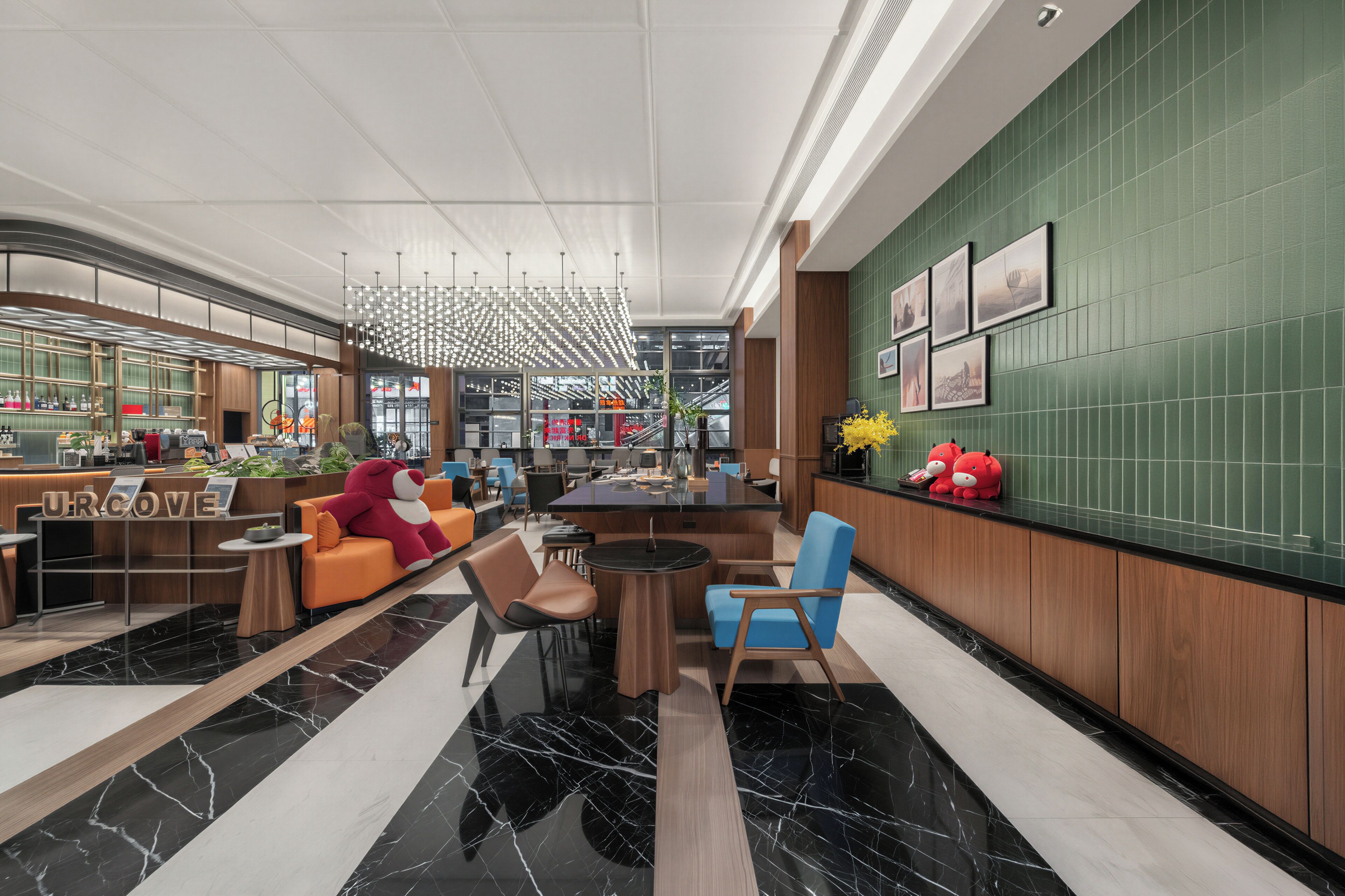 Een moderne lobby met een receptiebalie, een zithoek en een bar.