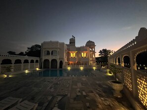 A large building with multiple arches and a pool area. - The Kumbha Mahal Resort (Kumbhalgarh)