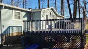 Ein Haus mit einem umzäunten Deck, einer Garage und einer überdachten Terrasse.