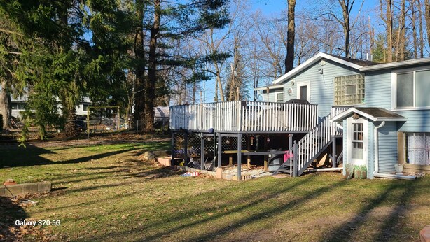 Ein zweistöckiges Haus mit umzäunter Terrasse und einer kleinen Veranda.