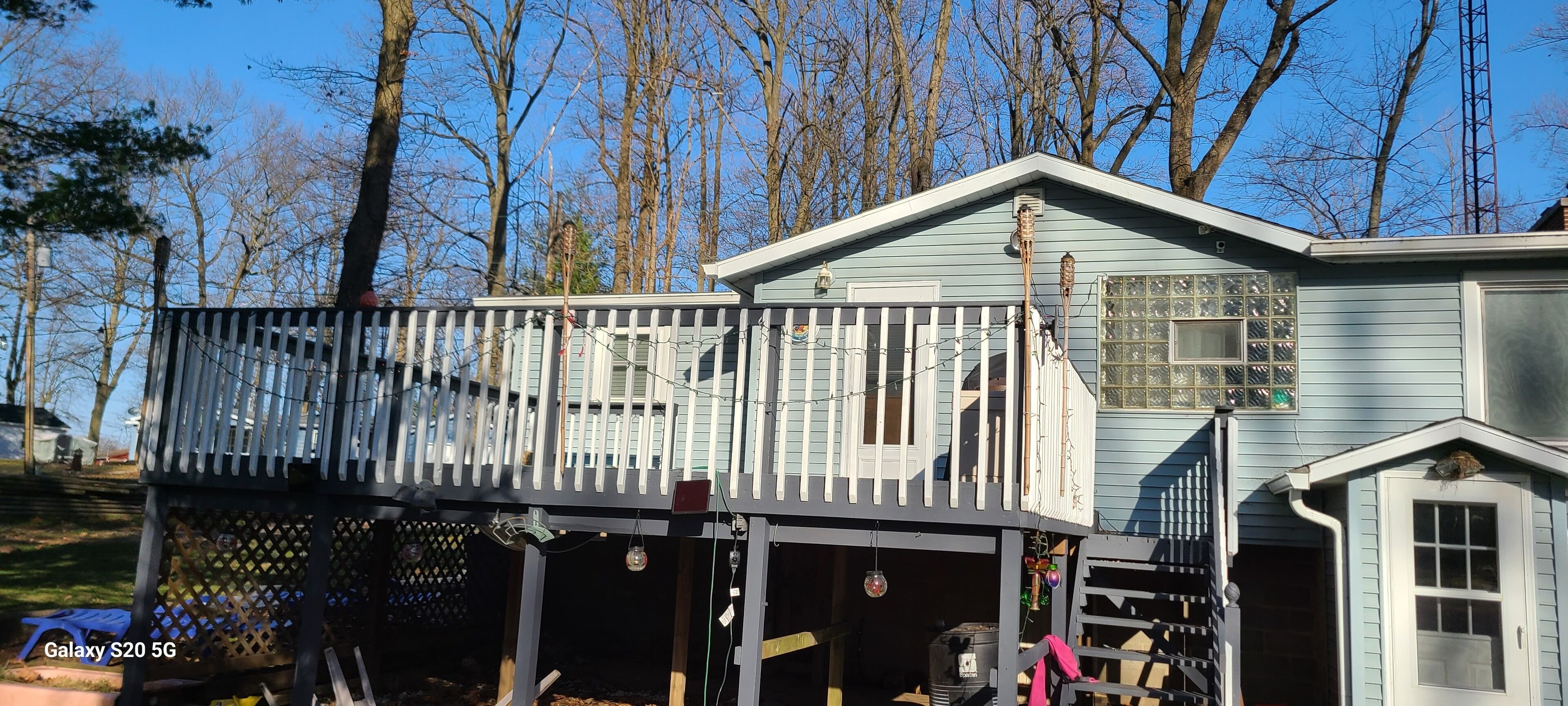 A two-story house with a balcony, a garage, and a small shed.