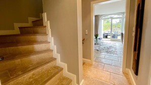 A staircase leading to a room with a view of a patio area. - Beachhouse Seaside 3 - Beachhouse Seaside 3 Rantum, 107qm mit 3 Schlafzimmern für bis zu 6 Personen (Sylt)