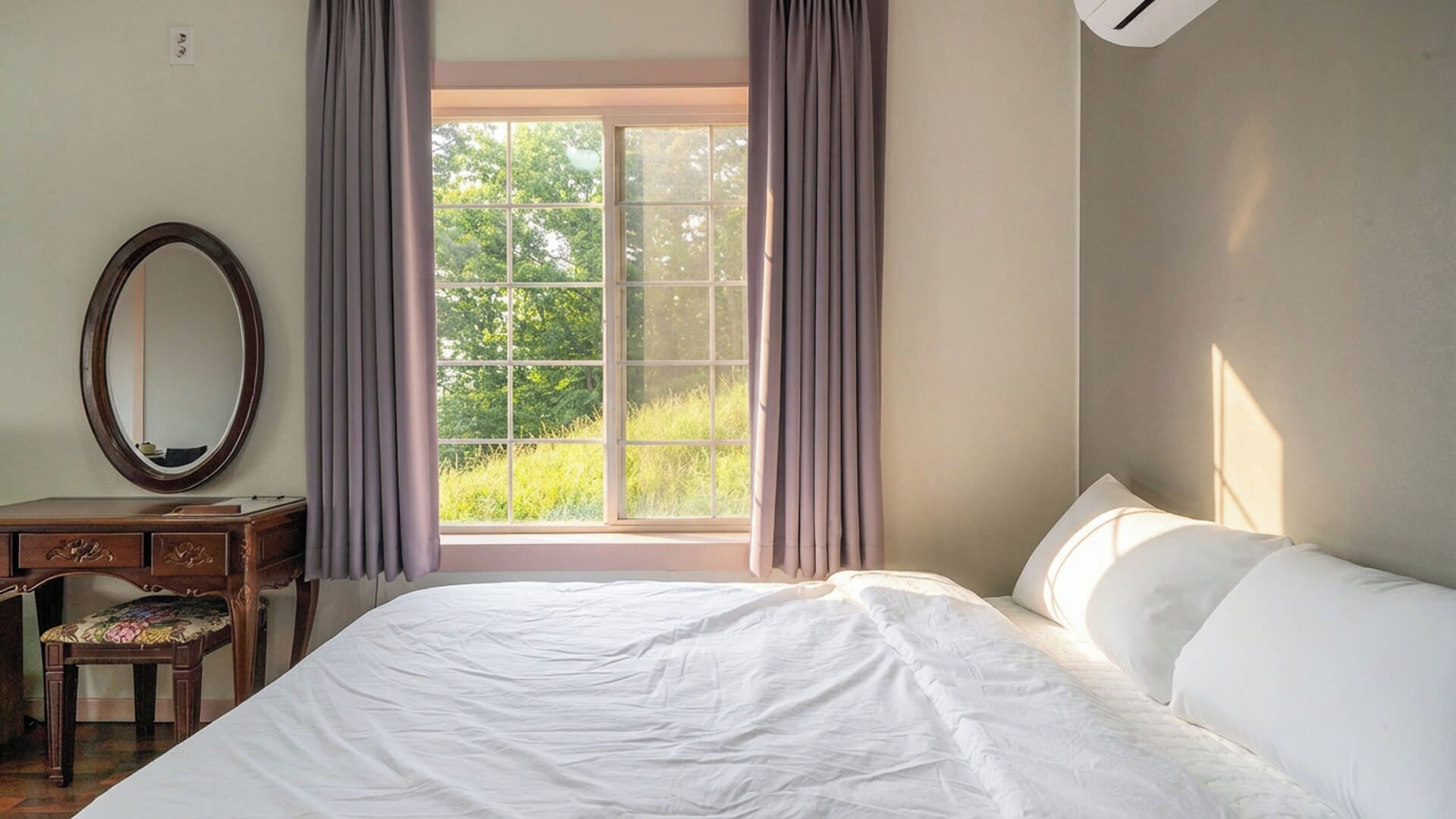 A bedroom with a large bed, a dresser, a mirror, and a window with curtains.
