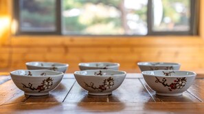 Seis cuencos de cerámica con motivos florales sobre una mesa de madera en una habitación con ventana.