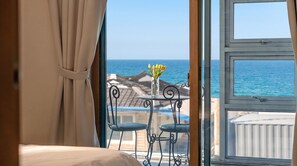 A room with a view of the sea, a table with chairs, and a vase with flowers. - Samcheok Jangho Sanho Pension (Samcheok)