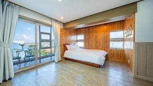 Un dormitorio con un ventanal grande, una cama y paneles de madera.