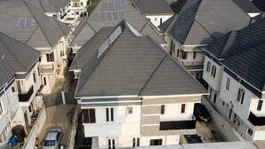 A residential area with multiple houses, each with a sloped roof and solar panels. - Impeccable 4-Bed House in Lagos  Nigeria (Lagos)