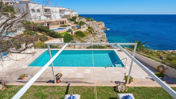 A pool with a view of the sea and buildings in the background. - Magrana Over The Sea (Private Pool). by Interhome (Porto Cristo)