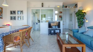 A modern living room with a TV, sofa, and dining area. - Magrana Over The Sea (Private Pool). by Interhome (Porto Cristo)