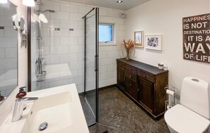 A modern bathroom with a glass shower enclosure, a white sink, a dark wooden vanity, and a toilet. - 3 bedroom beautiful home in Hörby (Hörby)