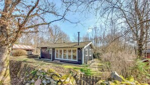 A small house with a tiled roof, surrounded by trees and a stone wall. - 3 bedroom beautiful home in Hörby (Hörby)