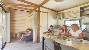A cozy living area with a wooden interior, a sofa, and a table where people are playing a board game.