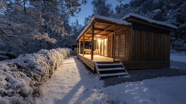 A wooden cabin with a covered porch and a staircase leading to the entrance.
